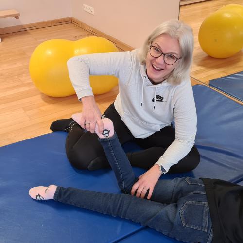 Physiotherapeutin und ein Kind bei der Durchführung von Übungen