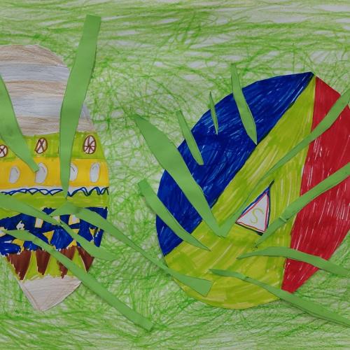 Die Kinder haben ein Zeichenblatt mit grüner Wachskreide bemalt. Anschließend wurden 2 große Eier aufgezeichnet und mit bunten Filzstiften verziert. Nun klebten die Kinder grüne Tonpapier-Grashalme davor.