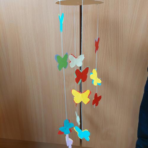 bunte Schmetterlinge hängen unter einem Kartonkreis