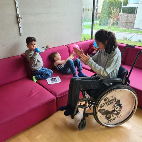 Kinder spielen auf der Couch, ein Kind schaut zu