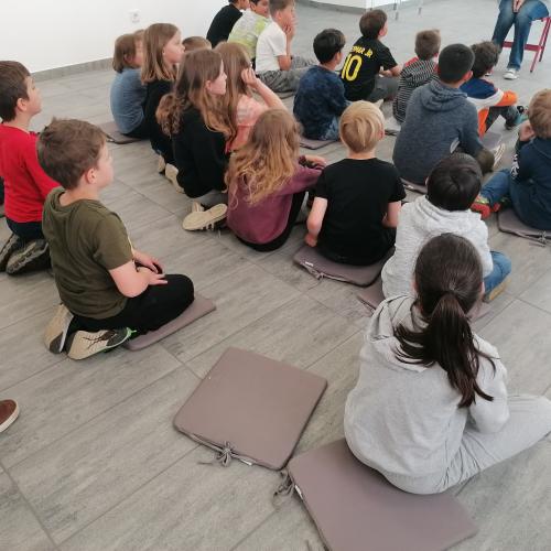 Kinder sitzen am Boden in der Galerie
