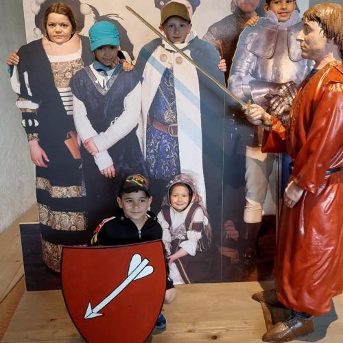 Kinder gucken aus Pappkartonfiguren aus dem Mittelalter heraus