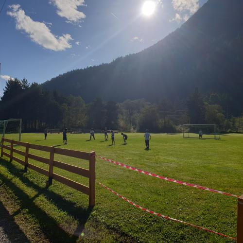 Kinder spieln Fußball am Sportplatz