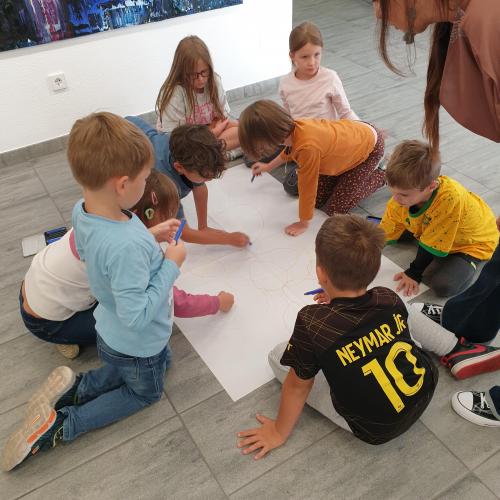 Kinder zeichnen auf ein Plakat