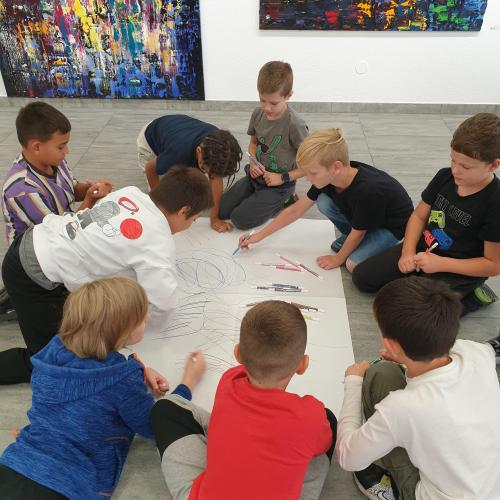 Kinder zeichnen auf ein Plakat
