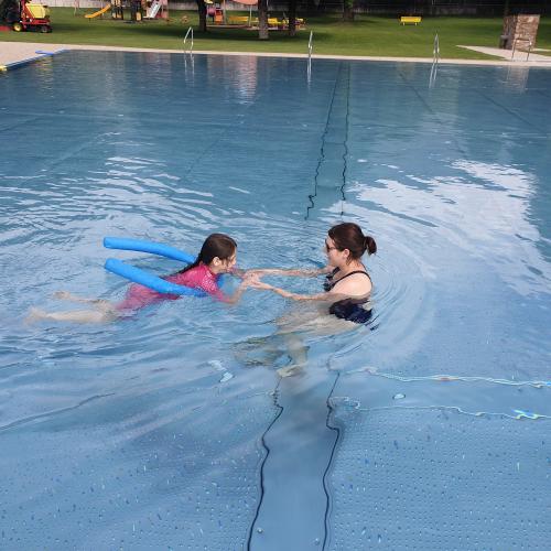 Kind und Schwimmlehrerin im Becken