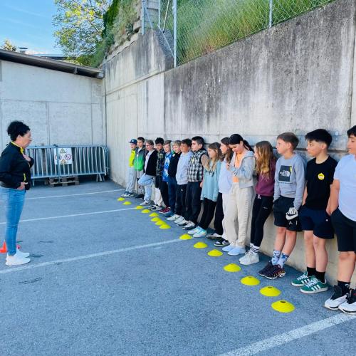 Kinder stehen in einer Reihe und hören der Instructorin zu