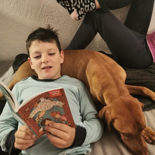 Bub liest seiner Schwester und dem Hund vor