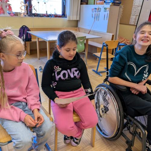 Mädchen liest eine Geschichte vor, 2 Mädchen hören zu