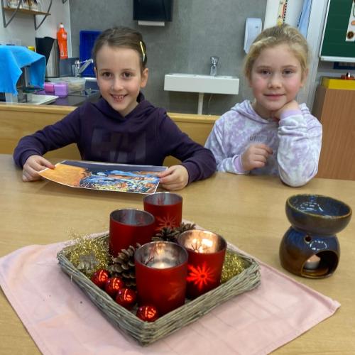 2 Mädchen sitzen am Adventkranz