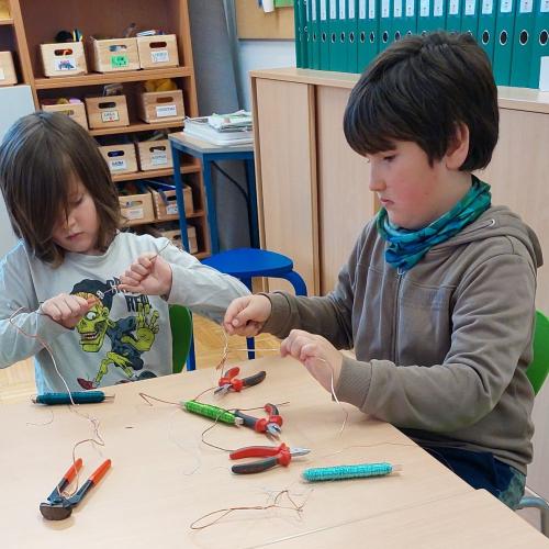 2 Buben arbeiten mit Kupferdraht