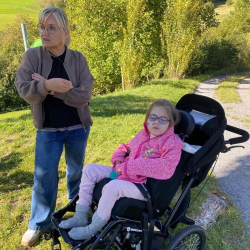 Mädchen im Rollstuhl mit ihrer Betreuerin