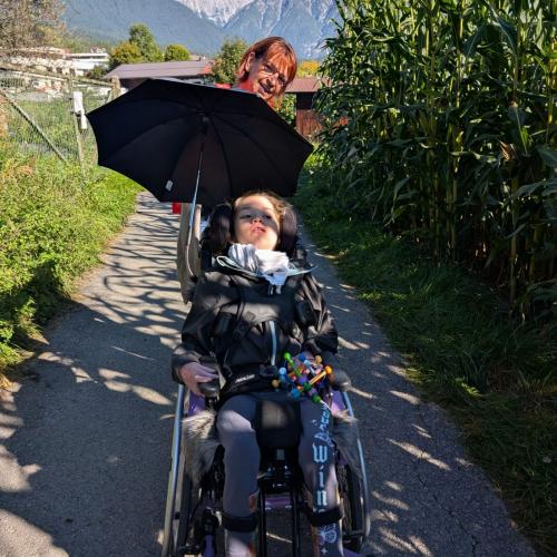 Mädchen im Rollstuhl mit ihrer Betreuerin