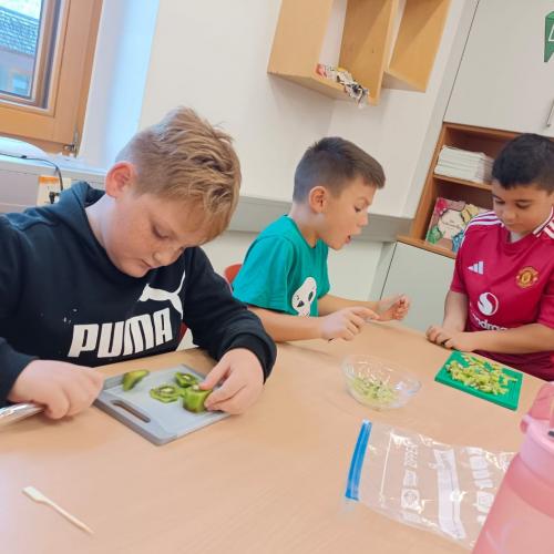 Buben schneiden Obst und haben Spaß dabei