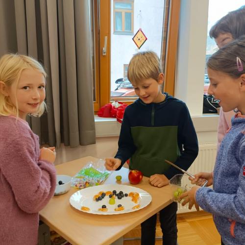 Kinder bereiten einen bunten Obstteller