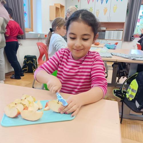 Mädchen schneidet Äpfel klein auf