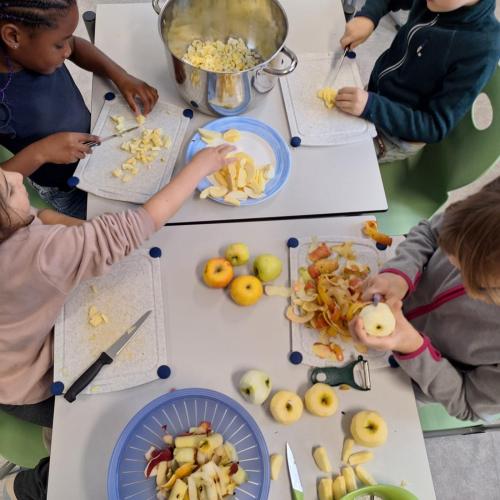 Kinder beim Äpfel schälen und klein aufschneiden