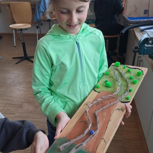 Mädchen präsentiert stolz ihre Kugelbahn