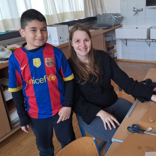 Bub zeigt seiner Lehrerin sein Kunstwerk