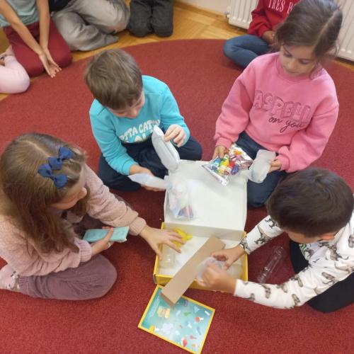 4 Kinder der 1. Klasse öffnen die Experimentierschachtel