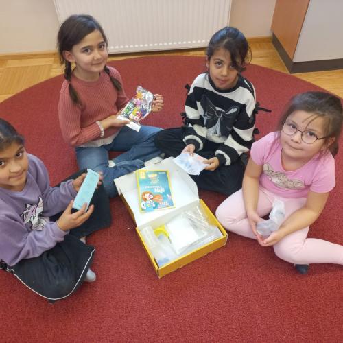 4 Mädchen der 1. Klasse durchforsten das Experimentierset