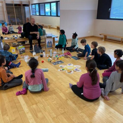 Kinder sitzen im Kreis und lauschen Robis Geschichten