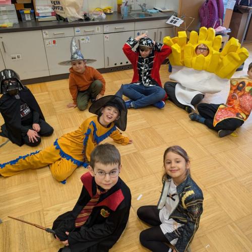 verkleidete Kinder sitzen am Boden