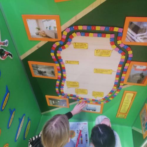 2 Mädchen lesen an einer Plakatwand