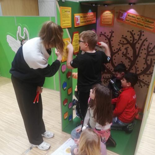 Kinder arbeiten an einer Plakatwand