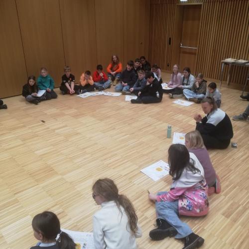 Kinder sitzen im Sitzkreis