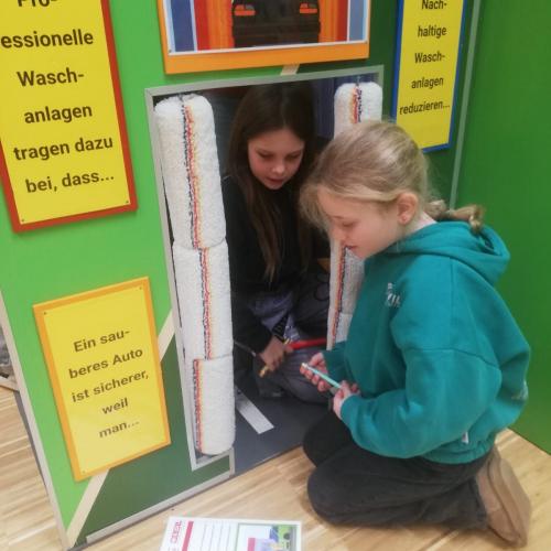 2 Mädchen arbeiten an einer Plakatwand