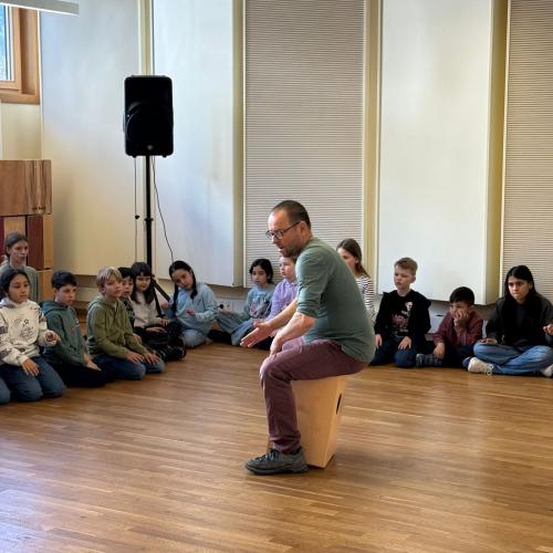 Lehrer spielt auf einem Cajon