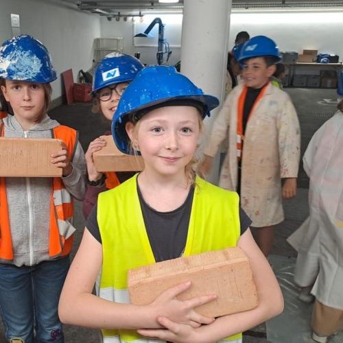 Kinder tragen Ziegelsteine