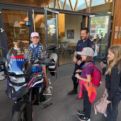 ein Mädchen sitzt stolz auf dem Polizeimotorrad