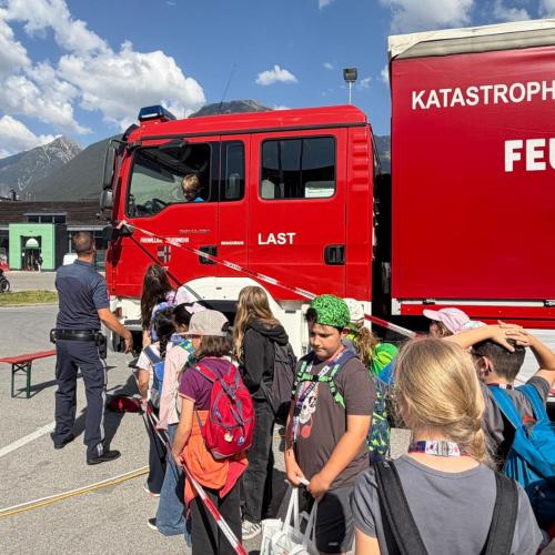 Kindergruppe schaut das ein Feuerwehrauto an