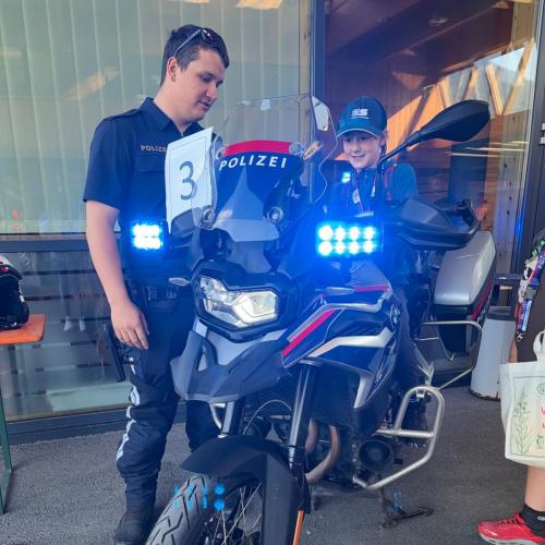 Bub sitzt auf dem Polizeimotorrad und darf das Blaulicht einschalten