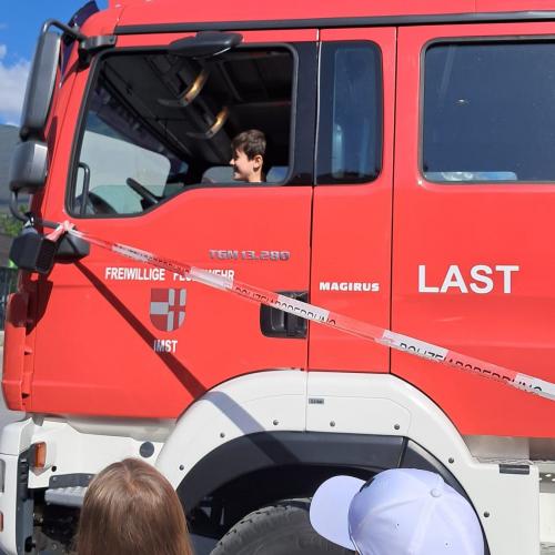 ein Bub sitzt im Feuerwehrauto