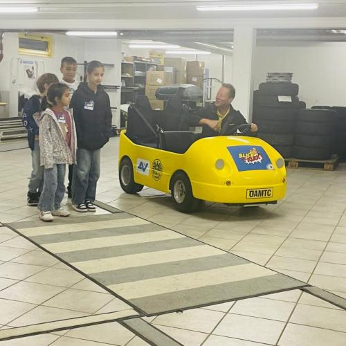 Kinder warten am Zebrastreifen und achten auf das Auto