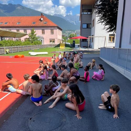 alle Kinder sitzen im Schatten des Hauses