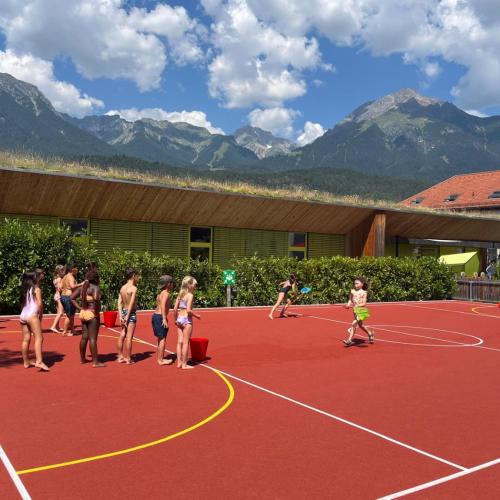 Kinder spielen in Badekleidung auf dem Sportplatz