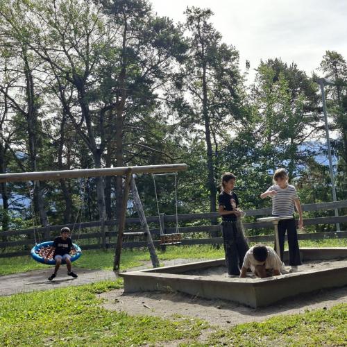 Kinder spielen in der Sandkiste und schaukeln