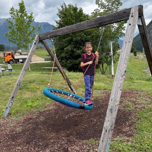 Mädchen steht auf der Nestschaukel