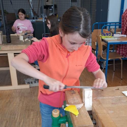 Mädchen arbeitet angestrengt und konzentriert mit der Feile