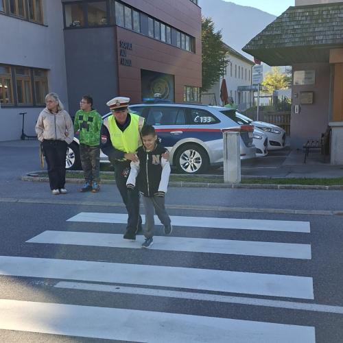 Bub geht mit der Polizistin über die Straße