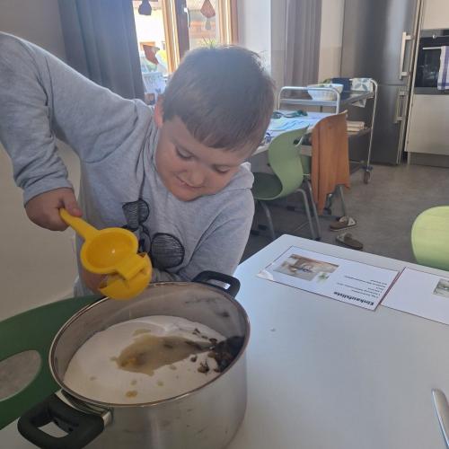 Bub presst Zitronensaft auf die Zwetschken