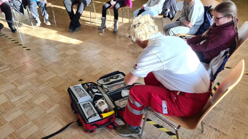 Sanitäterin stellt den Erste Hilfe Koffer vor
