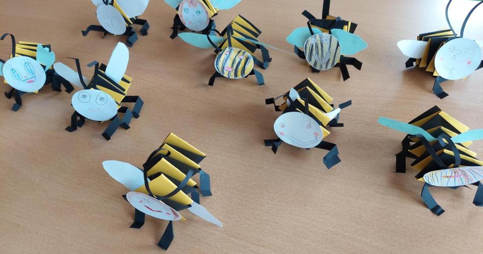 Mehrere selbstgebastelte Bienen aus Tonpapier befinden sich auf dem Tisch