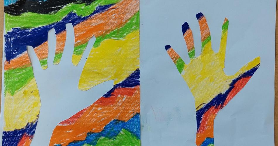 buntes Zeichenblatt + ausgeschnittene Hand