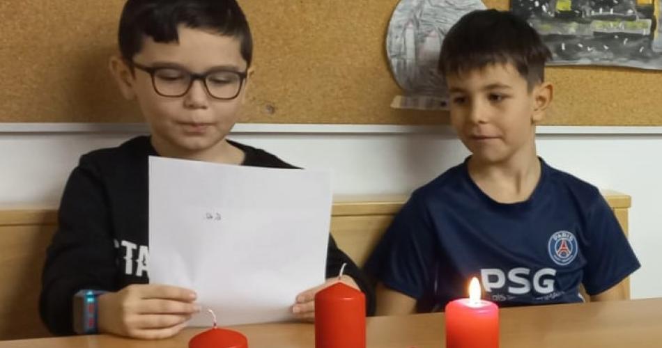 2 Buben lesen am Adventkranz