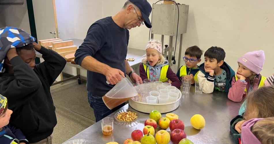 Kinder beim Apfelsaft pressen